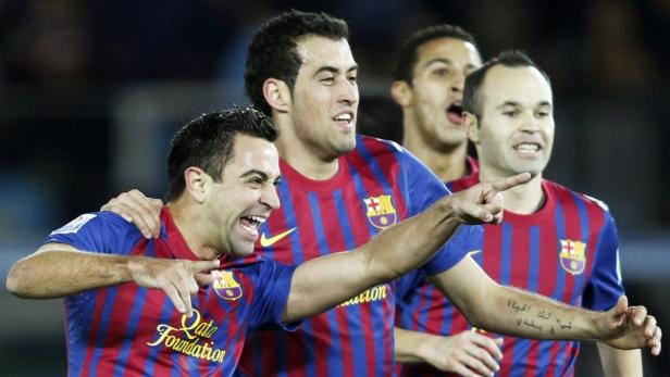 Die Fußballspieler Xavi, Sergio Busquets und Andrés Iniesta vom FC Barcelona jubeln.