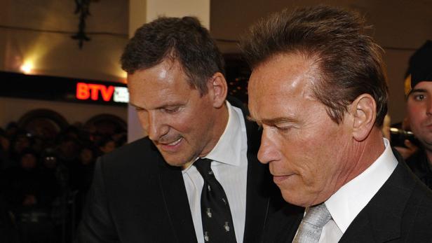 Arnold Schwarzenegger mit einem Mann im Anzug bei einer Veranstaltung.