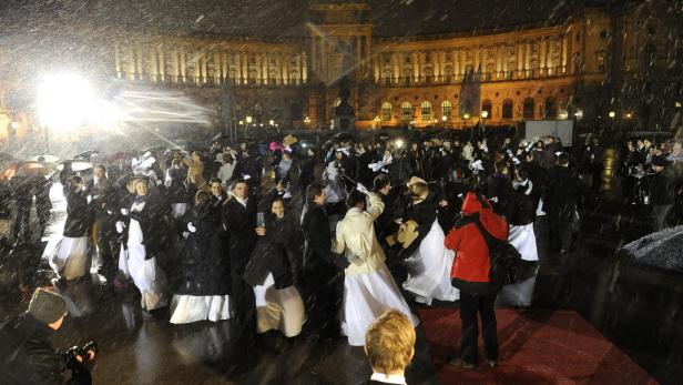 Trotz starken Schneefalls verlassen Ballbesucher die Wiener Hofburg.