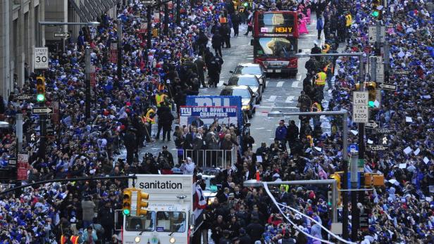 Eine Parade für die New York Giants nach ihrem Super Bowl XLVI Sieg in einer von Menschenmassen gesäumten Straße.
