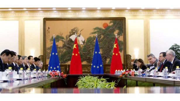 Delegationen der EU und Chinas sitzen an einem Tisch mit ihren Flaggen.