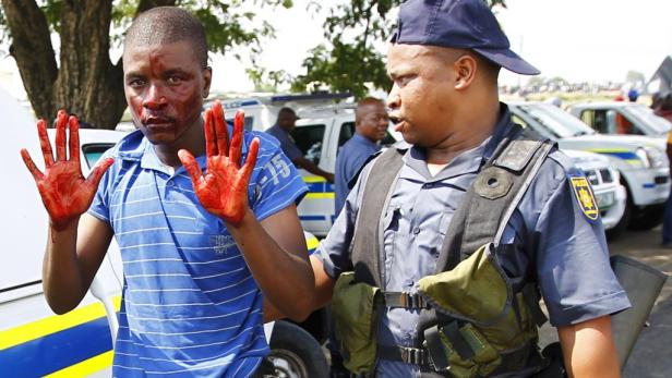 REUTERSPolice arrest a protester near Impala Platinums Rustenburg mine, February 16, 2012, as a month-long strike at the worlds second-largest producer of the precious metal turned violent. South African riot police fired tear gas, rubber bullets and wate