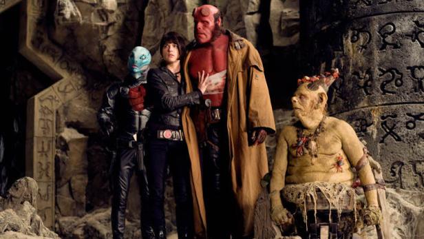 Hellboy und andere Charaktere stehen in einer Höhle.