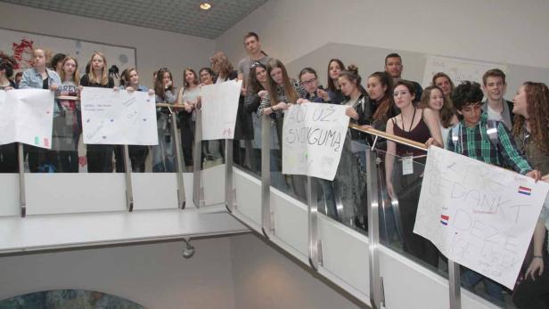 Die Jugendlichen des Erasmus-Plus-Projekts &quot;Increase&quot; versammeln sich am letzten Tag im Schulhaus und halten vielsprachige Plakate ins Stiegenhaus
