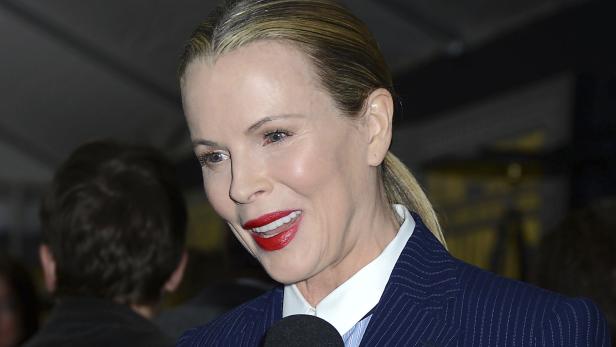 Kim Basinger lächelt in einem gestreiften Blazer.