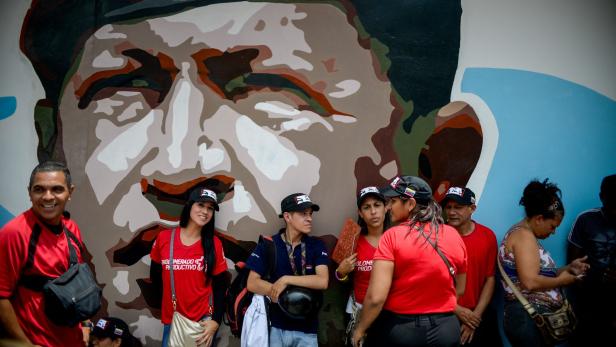 Anhänger von Präsident Nicolas Maduro vor einem Plakat des verstorbenen Hugo Chavez.