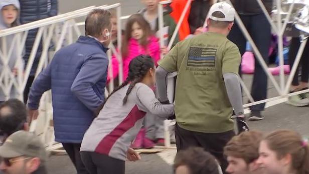 Zuschauer stehen hinter Absperrungen bei einer Veranstaltung.