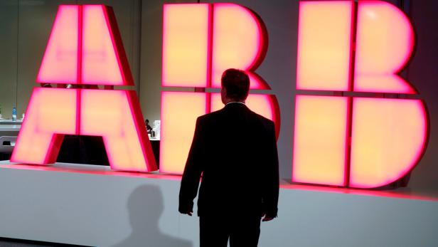 A man stands in front of the logo of Swiss engineering group ABB before a news conference in Zurich, Switzerland October 4, 2016. REUTERS/Arnd Wiegmann