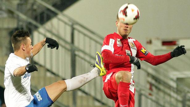 Zwei Fußballspieler kämpfen um den Ball.