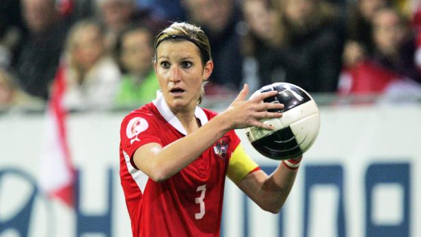 Eine österreichische Fußballspielerin hält einen Ball in ihren Händen.