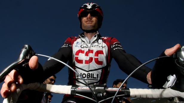 Ein Radfahrer in Sportkleidung und Helm fährt auf einem Rennrad.