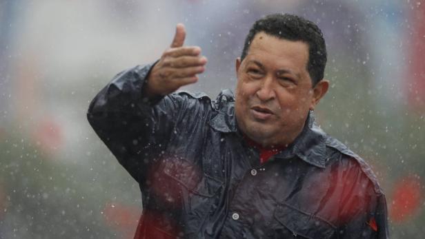 Hugo Chávez gestikuliert im Regen.