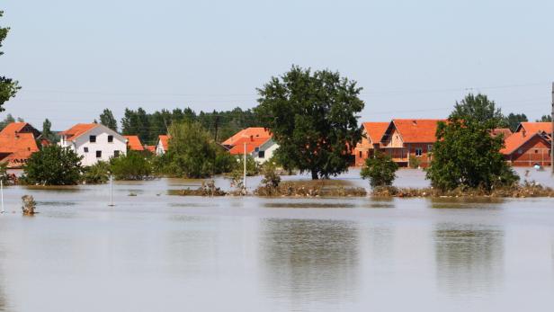 Überschwemmtes Wohngebiet mit Häusern, deren Dächer aus dem Wasser ragen.