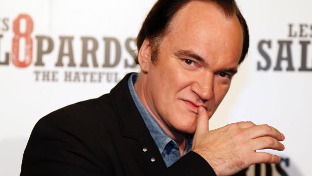 Quentin Tarantino posiert vor einem Poster für den Film „The Hateful Eight“.