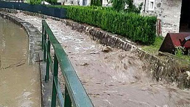 Ein über die Ufer getretener Fluss fließt durch eine Stadt.