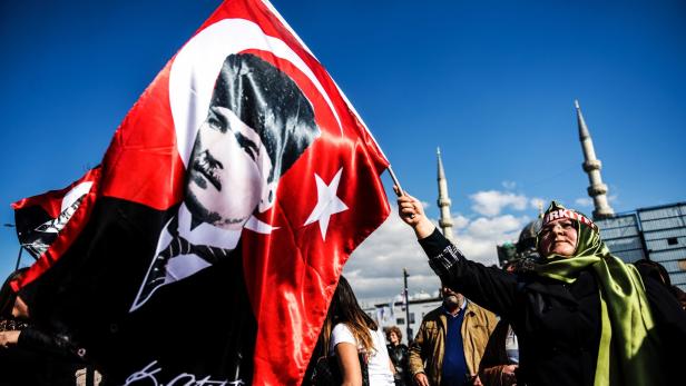 Eine Frau schwenkt eine Flagge mit Atatürk-Konterfei