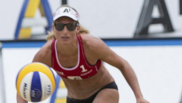 Eine Beachvolleyballspielerin baggert einen Ball.