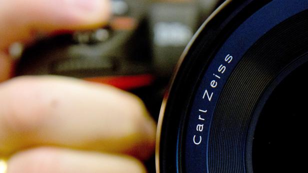 Nahaufnahme eines Carl Zeiss Kameraobjektivs.