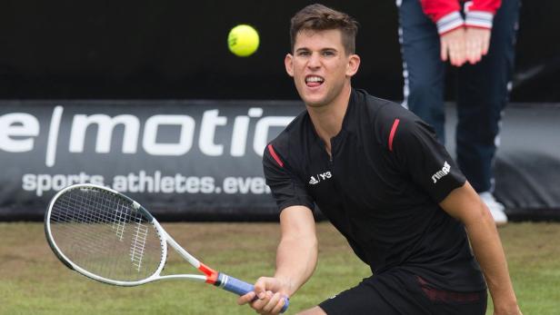 Dominic Thiem spielt Tennis und streckt die Zunge heraus.