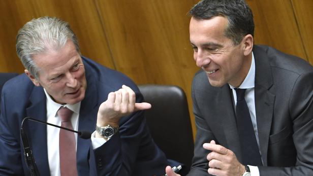 Zwei Männer in Anzügen unterhalten sich angeregt.