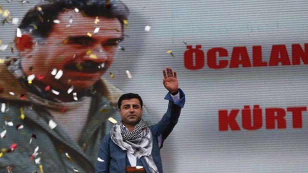 Selahattin Demirtas, co-chairman of the pro-Kurdish Peace and Democracy Party, greets his supporters during a rally to celebrate the spring festival of Newroz in Istanbul March 17, 2013. A picture of imprisoned PKK leader Abdullah Ocalan is seen in the background. REUTERS/Murad Sezer (TURKEY - Tags: POLITICS CIVIL UNREST)