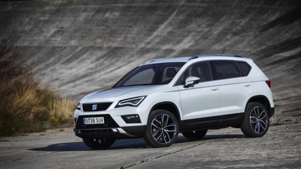 Ein weißer Seat SUV steht vor einer Betonwand.