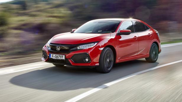 Ein roter Honda Civic fährt auf einer asphaltierten Straße.