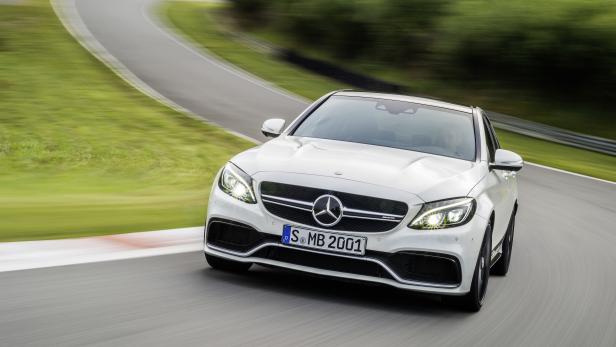Ein weißer Mercedes-Benz AMG fährt auf einer Rennstrecke.