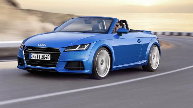 Ein blauer Audi TT Roadster fährt auf einer Küstenstraße.