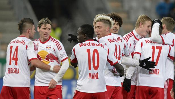 Fußballspieler von Red Bull Salzburg feiern gemeinsam auf dem Spielfeld.