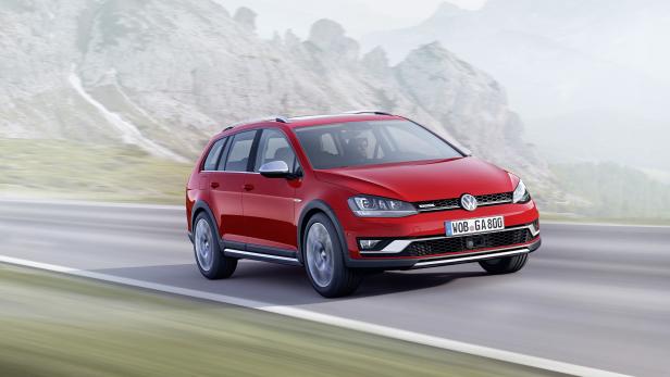 Ein roter VW Golf Alltrack fährt auf einer Straße vor einer Bergkulisse.