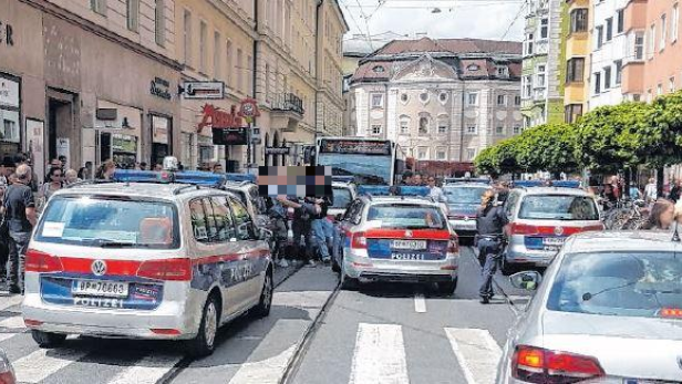 Polizeiauto blockieren eine Straße in einer Stadt.