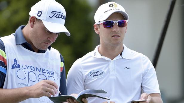 Zwei Männer, vermutlich Golfspieler und Caddie, während eines Golfturniers.