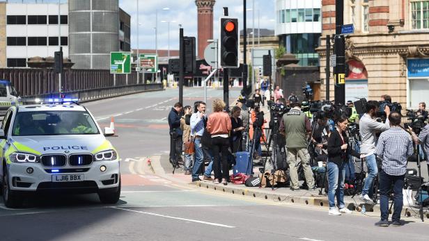 Medienvertreter vor einer Absperrung in Manchester