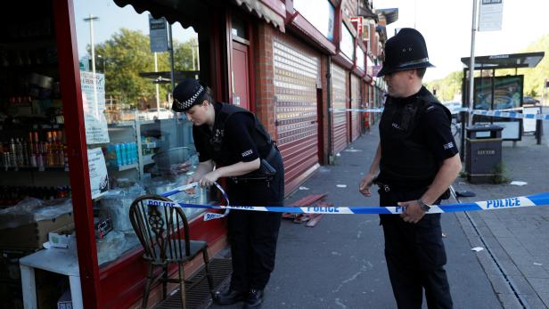 Die Polizei sperrte einen Frisörladen in Moss Side ab.