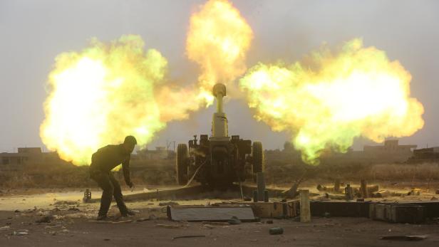 Ein Soldat feuert eine Haubitze ab, wobei große Stichflammen entstehen.