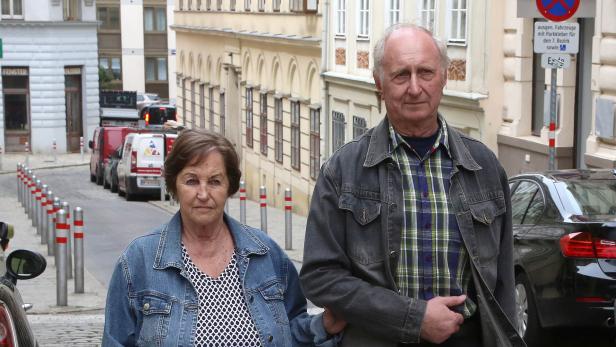 Ein älteres Paar steht auf einer Straße in der Stadt.