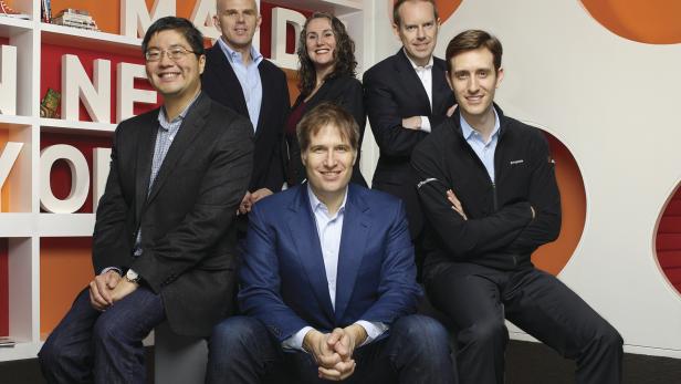 Eine Gruppe von sechs Personen posiert vor einem Hintergrund mit dem Schriftzug „MAUS“.