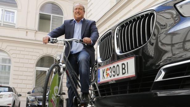 Umweltlandesrat Rolf Holub mit Dienst-Rad und Dienst-BMW