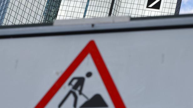 Ein Baustellenschild vor dem Gebäude der Deutschen Bank in Frankfurt.