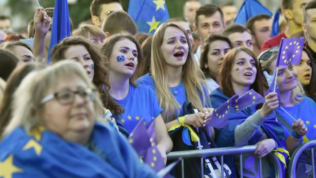 People wave European Union flags during a mass open-air concert on European Square in Kiev on June 10, 2017, dedicated to the abolition of EU visas for Ukrainian citizens. Ukraine celebrates of visa-free travel to Europe as a waiver agreed with the EU enters into force on June 11. / AFP PHOTO / Sergei SUPINSKY