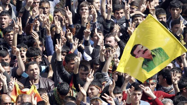 epa03634329 Kurdish people shout slogans as they hold pictures of PKK leader Abdullah Ocalan during a rally Newroz celebration in Diyarbakir, Turkey 21 March 2013. The jailed leader of the separatist Kurdistan Workers Party (PKK), Abdullah Ocalan, declared a ceasefire with Turkey on Thursday. Ocalan urged PKK fighters to disarm and withdraw from the country and for armed struggle to make way for politics, in a widely expected statement, the Firat news agency reported. EPA/SEDAT SUNA