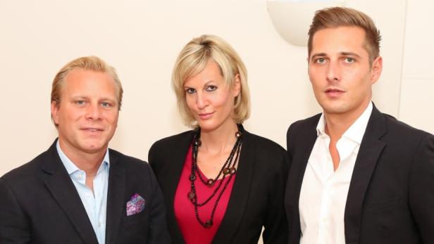 Eine Frau und zwei Männer posieren für ein Gruppenfoto.