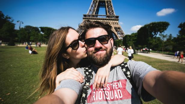 Romantic couple making selfie in front of Eiffel T…