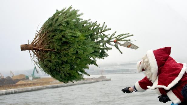 Ein Weihnachtsmann wirft einen Weihnachtsbaum in einen Fluss.