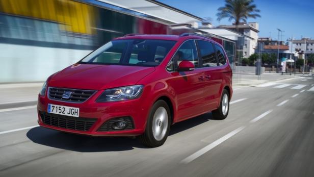 Ein roter Seat Alhambra fährt auf einer Straße in einer Stadt.