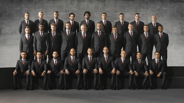 Ein Gruppenfoto der Fußballmannschaft des FC Bayern München in Anzügen.