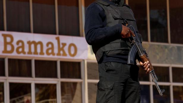 Ein bewaffneter Wachmann steht vor einem Gebäude in Bamako.