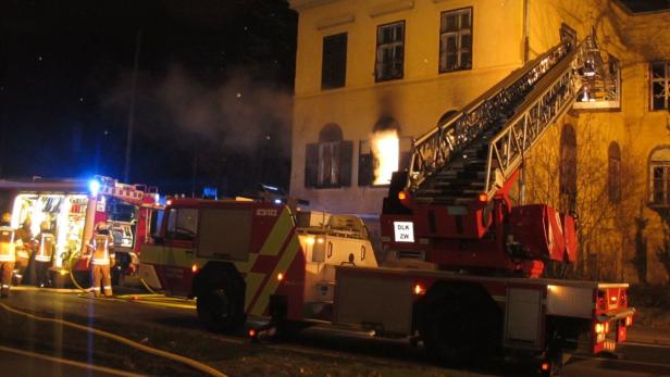 Ein Feuerwehreinsatz an einem Gebäude in der Nacht.