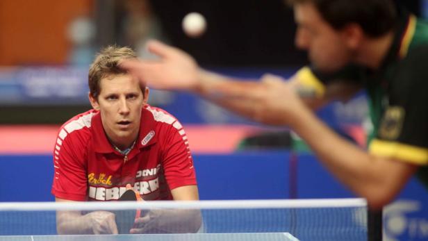 Ein Tischtennisspieler im roten Trikot erwartet den Aufschlag seines Gegners.